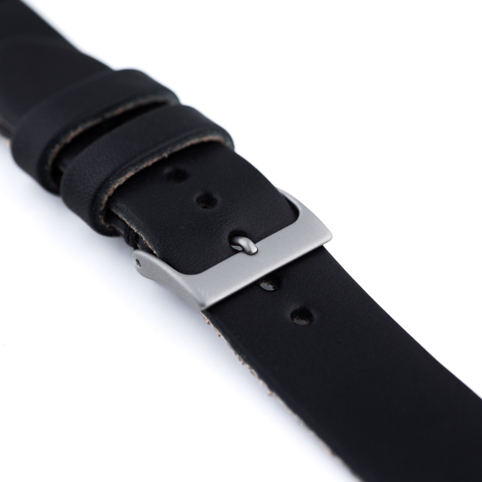 Black leather watch strap with silver buckle on a white background