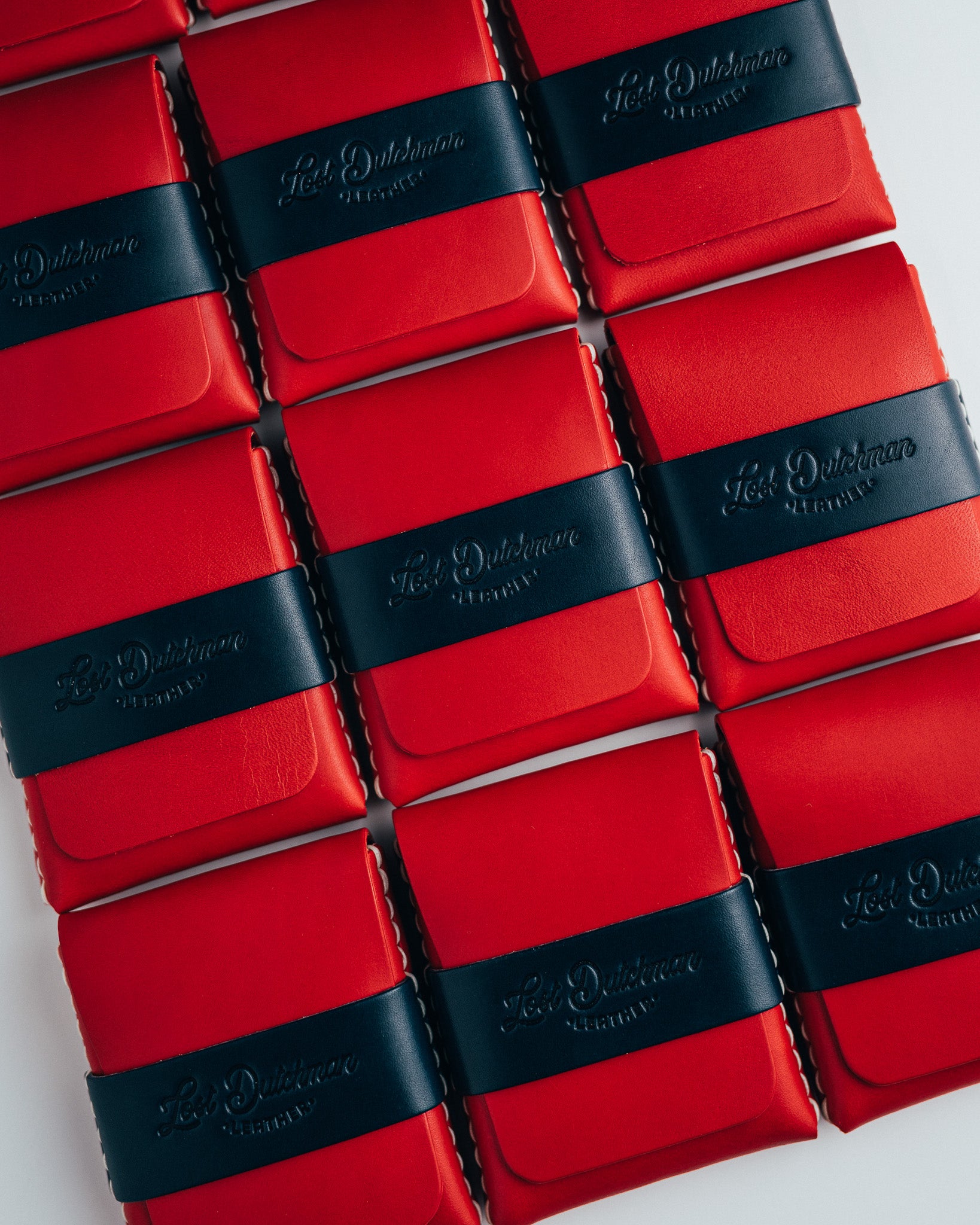 Rows of red leather wallets with dark bands