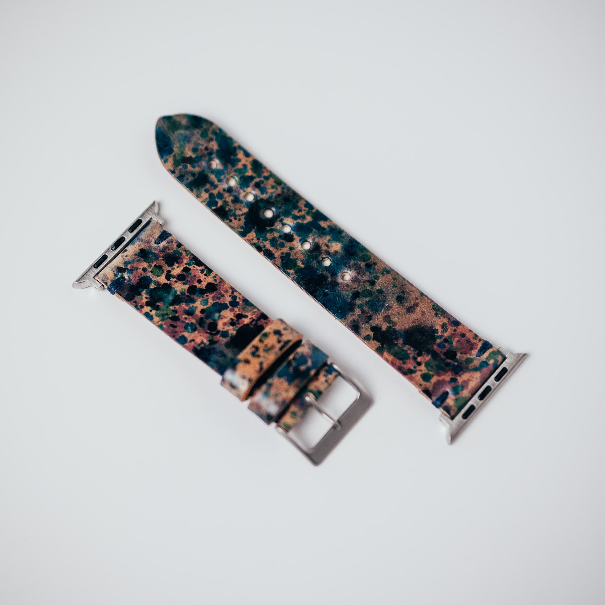 Two patterned leather watch straps on a white surface