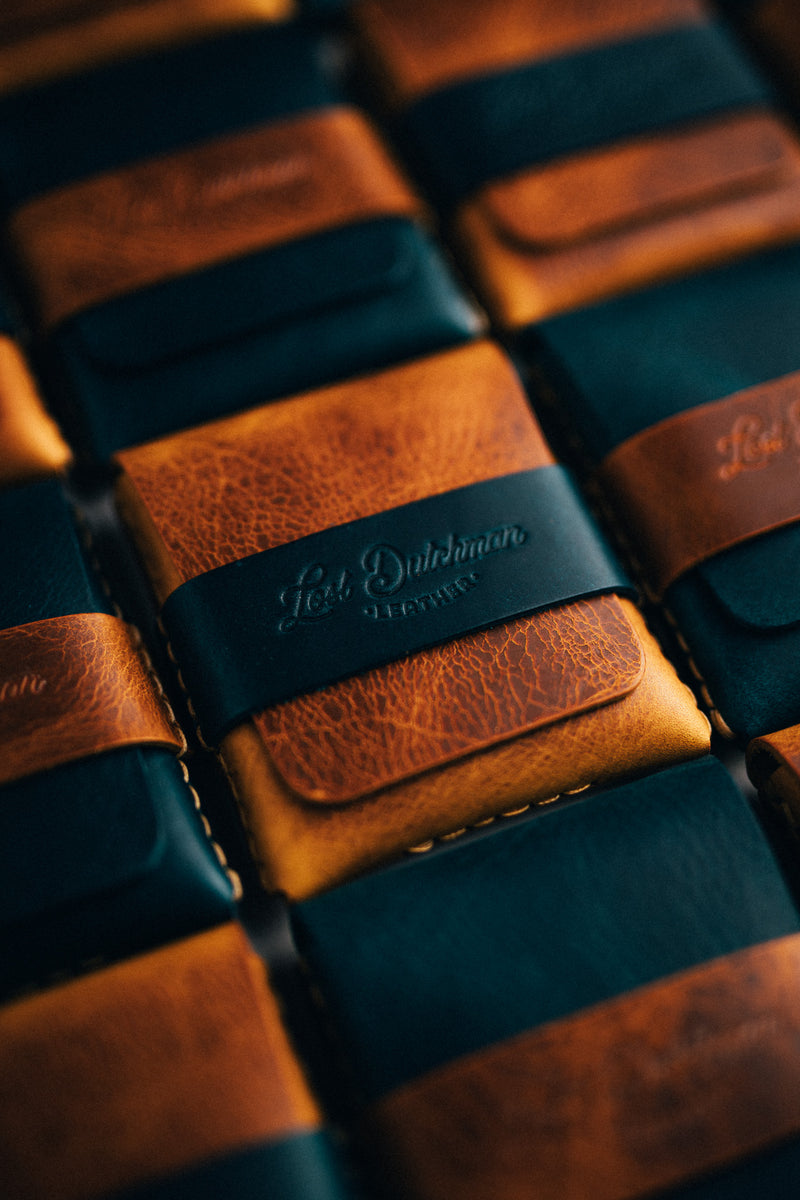Stacked dark teal and brown leather card holders