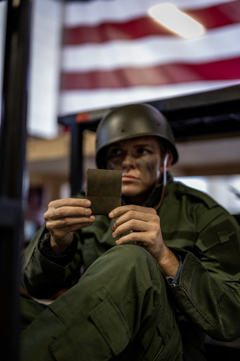 Person in military uniform holding a leather wallet