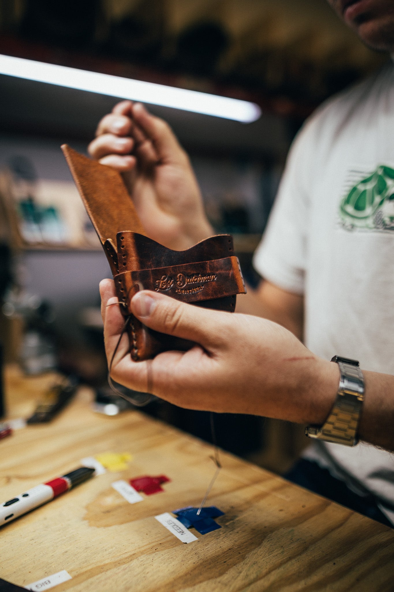 Person working on leather at a workbench