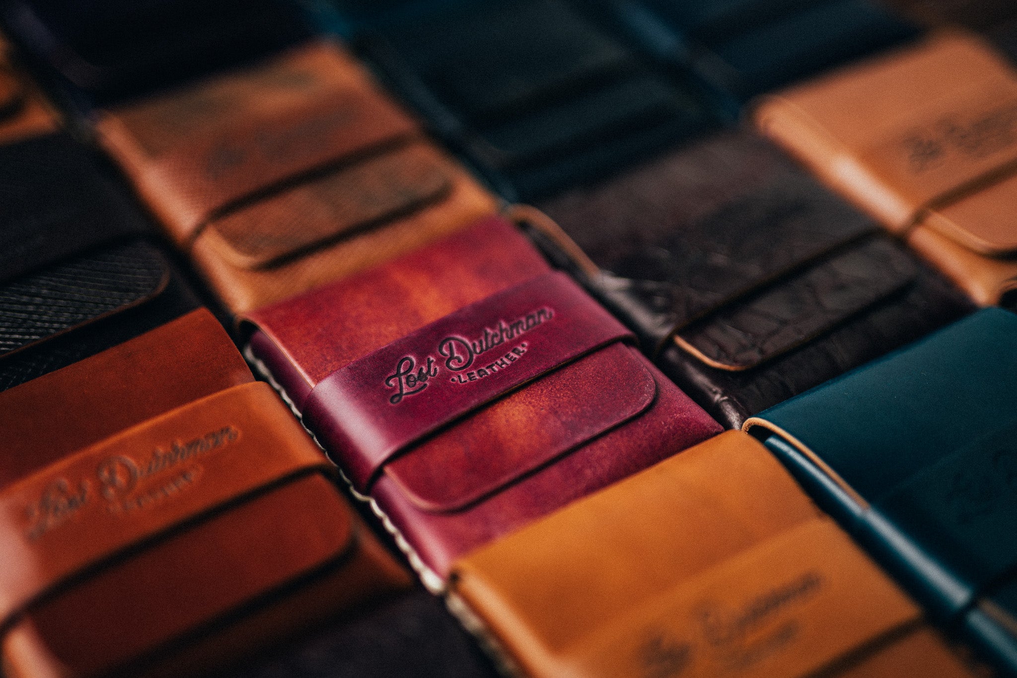 Close-up of stacked leather wallets in brown, burgundy and orange
